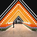 2023 S7 Event Passage Triangular Structure with Orange Lights People Standing and Green Plants