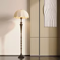 Elegant Floor Lamp With Scalloped White Lampshade And Decorative Metal Stand By Wooden Cabinet
