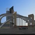 Modern Entrance Gate with Arch Design Tower Structures Red Signs Green Lawn and Cars
