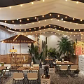 Cozy Bar Interior Design With String Lights Wooden Tables Chairs Umbrella And Green Plants