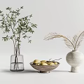 Glass Vase With Green Branches And White Vase With Feathery Plants Alongside Wooden Bowl Of Lemons