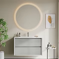 Elegant Bathroom Vanity Featuring Light Gray Cabinet Round Illuminated Mirror Decorative Painting and Green Plant