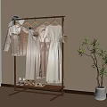 Stylish Clothes Rack With Hanging Dresses Hat And Shoes Near Potted Plant