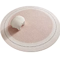 Round Pink Rug With White Black Dotted Border And Small White Pillow On Top