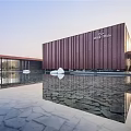 Modern Sales Office Building With Red Brown Perforated Metal Facade And Water Reflection