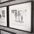 Black and White Framed People Scene Photos Hanging on Gray Wall