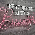 Stylish Neon Decorative Light with Be Your Own Kind of Beautiful Text on Wooden Wall