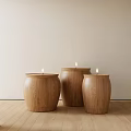 Three Wooden Candle Holders With Lit Candles On Light Colored Wall And Wooden Floor