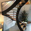 Modern Spiral Staircase Interior With Metal Railings Wooden Steps And Decorated Christmas Tree