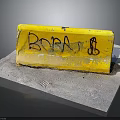 Yellow Road Barrier With Graffiti Featuring BOBA Text And Symbol On Concrete Ground