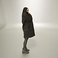 Woman In Black Long Coat With Headscarf Standing Against Gray Background