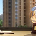 Decorative Ornament Set With Crystal Ball Open Book On Windowsill And Tall Buildings Green Trees