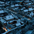 Scenic View of Traditional Village With Snow Covered Roofs Lit At Night And Snowy Trees