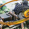 Intricate Golden Spiral Sculpture With Green Plants And Dark Round Fruits