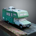 Green Vintage RV With Roof Equipment Parked On Gravel And Paved Area