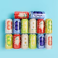 Colorful Fruit Flavored Drink Cans With Various Flavors Arranged Neatly On Light Blue Background