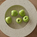 Green Apples Displayed On Light Colored Plate Over Wooden Table 3d model