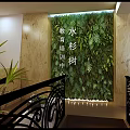 Cozy School Lounge With Green Chairs Round White Tables Wooden Bookshelves And Hanging Plants