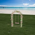 Scenic Seaside Flower Arch With Swing On Green Grass Under Blue Sky