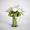White Flowers In Transparent Glass Vase With Green Leaves Yellow Accents And White Bow