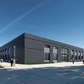 Modern Industrial Warehouse with Gray Exterior Large Glass Windows and People Walking Near Grass Area