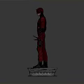 Red Superhero Statue Standing On Square Base With Red Costume And Daggers