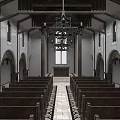Traditional Church Interior With Wooden Pews Arched Doors And Altar