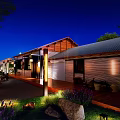 Rustic Guesthouse Building With Wooden Roof Stone Walls Front Porch Clay Pots Purple Flowers