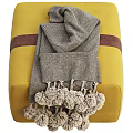 Stylish Yellow and Green Ottoman with Gray Pom Pom Blanket and Brown Strap Detail