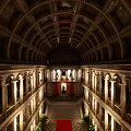 Grand Architectural Interior With Red Carpet Columns Symmetric Plants And High Ceiling