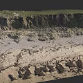 Waterfront Landscape With Sandy Shore Rocky Terrain And Green Vegetation