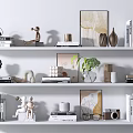 Stylish Decorative Ornament Combination with Sculptures Books Picture Frames and Green Plants on White Shelves