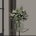 Green Glass Vase With White Flowers And Green Leaves On Metal Frame Glass Table