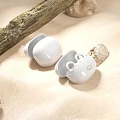 White Wireless Earbuds On Sandy Ground With Wooden Branch And Stones