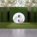 White Circular Sculpture With Symmetric Holes Against Green Hedge Wall And Gray Stone Floor