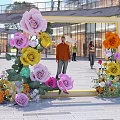 Colorful Flower Decorated Photo Check In Spot With Yellow Frame And Modern Building Background