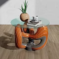 Glass Top Coffee Table With Orange Grey Curved Base Potted Plant White Cup And Books
