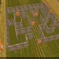 Outdoor Maze Photo Check In Spot With Stone Walls Green Grass And Orange EXIT Boxes