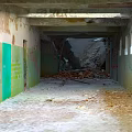 Abandoned Corridor With Peeling Paint Graffiti And Debris On Floor