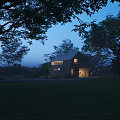 Modern Detached House at Dusk With Warm Lights Surrounded by Trees and Green Lawn