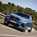 Blue BMW SUV Cruising On Scenic Curved Mountain Road With Green Trees