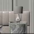 Elegant Marble Texture Bedside Table With White Shade Lamp Next To Beige Upholstered Bed