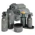 Sleep Themed Bath Essentials With Grey Bottles Rolled Towels And Jars On Tray