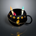 Black Mug With Gold Flower Decorations And Colorful Crayons Inside