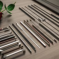 Various Metal Door Handles Displayed On Wooden Table With Red Rose And Green Leaves