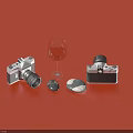 Decorative Ornament Set With Two Camera Models Wine Glass And Stones On Red Background