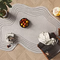 Stylish Shaped Rug with Curved Lines in Modern Living Room with Chair Fruit Bowl and Plant