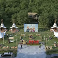 Camping Site Featuring Tepee Tents Outdoor Movie Screen And Lush Tree Surroundings