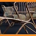 Modern Rattan Woven Leisure Chairs In Stylish Display With Dark Geometric Wall