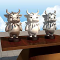 Three Silver White Cow Sculptures Decorative Art On Wooden Platform With Sky Clouds